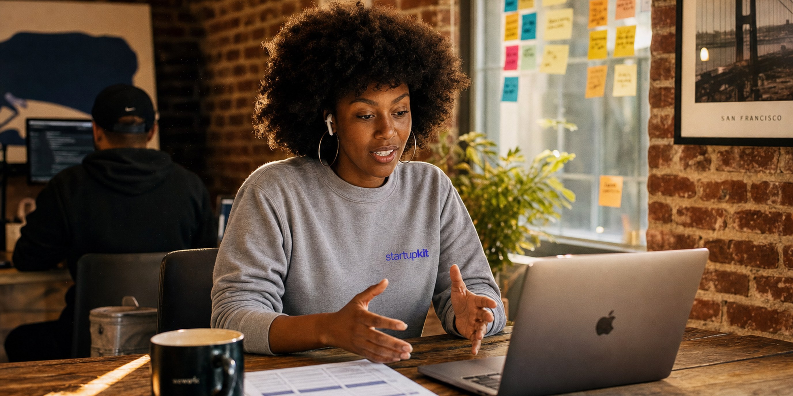 Solo founder running a structured candidate interview from a laptop in a sunlit startup office