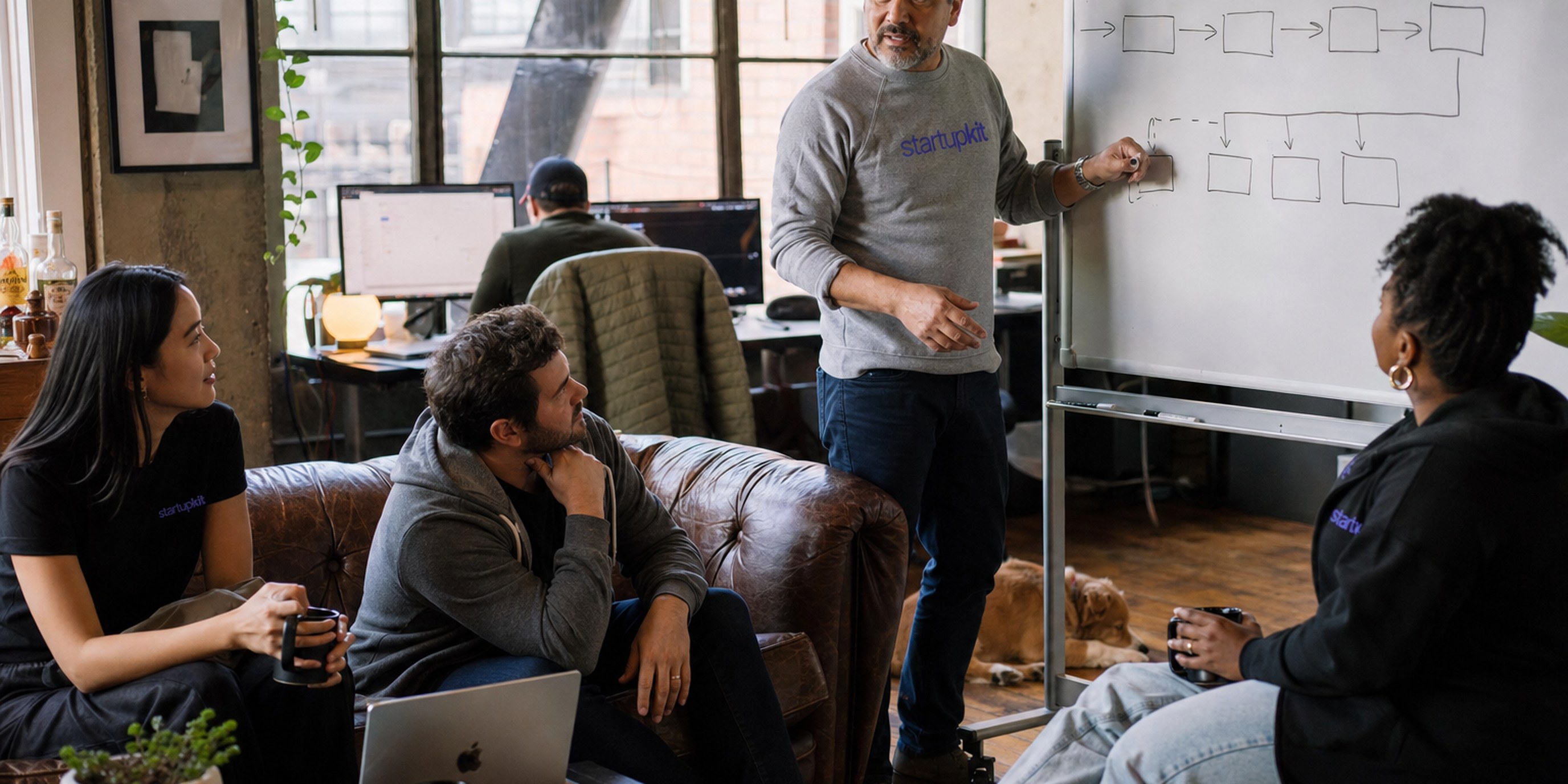 A fractional recruiter and a startup founder reviewing a candidate pipeline together on a laptop at a sunlit San Francisco co-working table