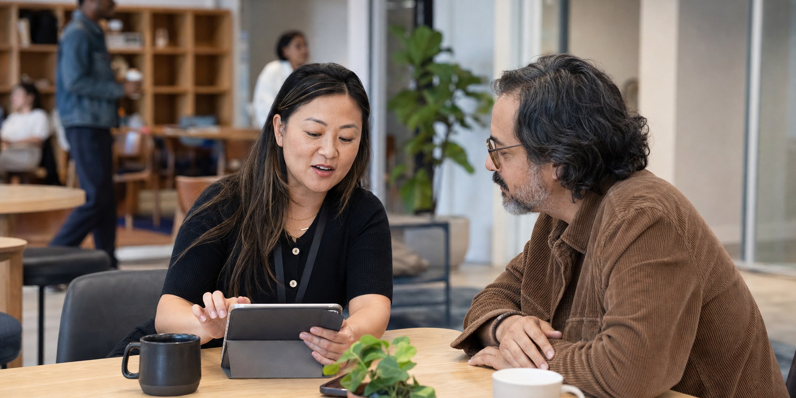 Benefits advisor explaining health plan and open enrollment options to an employee at a small-company desk