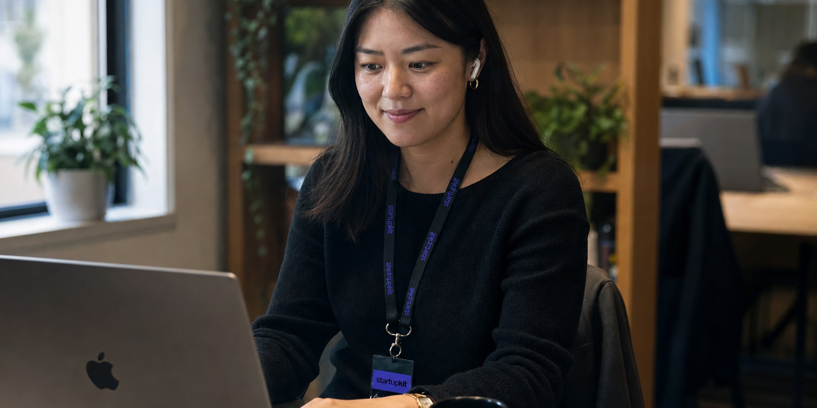 How to hire a recruiter: an in-house talent acquisition recruiter at her desk reviewing a candidate shortlist on a laptop during a video screening call
